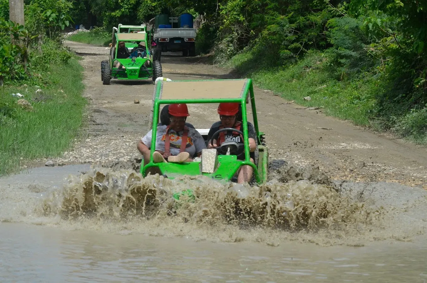 Two travelers riding a double buggy through a muddy trail